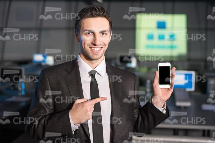 Good-Looking Business Man Pointing At Mobile Phone Stock Photo