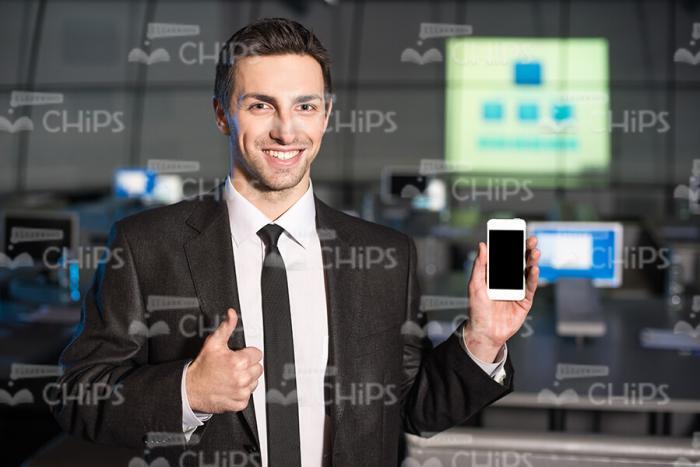 Young Business Man Holding Phone And Making Thumb Up Stock Photo