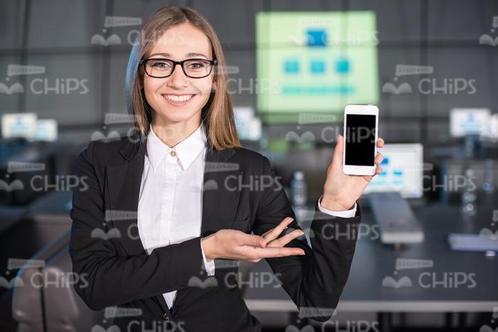 Young Business Woman Presenting Mobile Phone Stock Photo