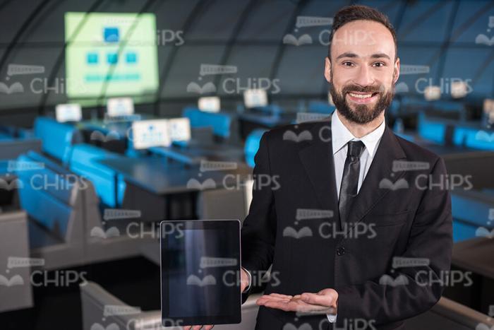 Smiling Business Man Presents Tablet Stock Photo