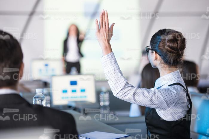 Young Woman Raising Hand Up While Wanting To Say Something Stock Photo