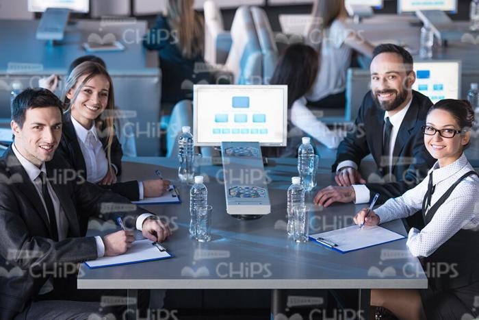 Young People Sitting Behind The Table At Conference Hall Stock Photo