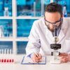 Male Researcher Using Microscope Stock Photo