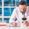 Medical Scientist Working With Microscope Stock Photo