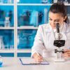 Young Woman Looking Through Microscope Stock Photo