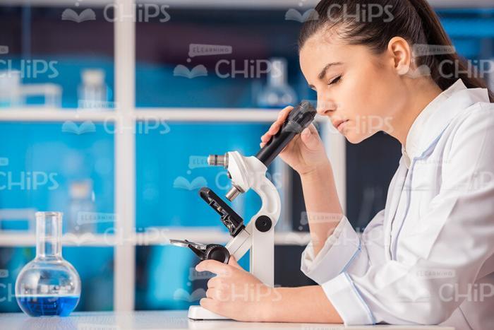 Young Woman Looking Through Microscope Stock Photo Profile View