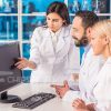 Team Of Scientists Working With Computer Stock Photo