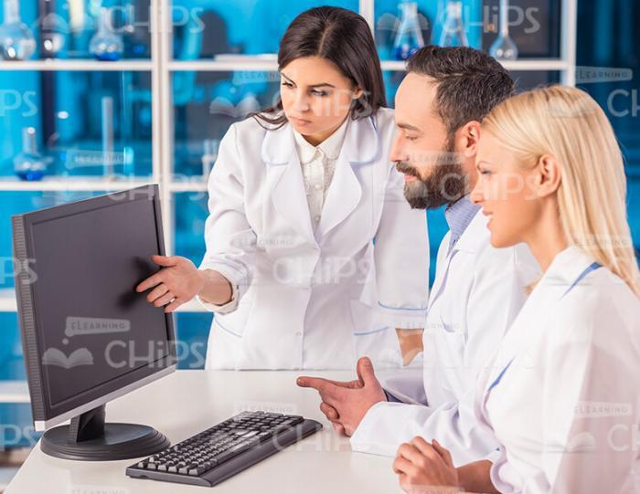 Team Of Scientists Working With Computer Stock Photo
