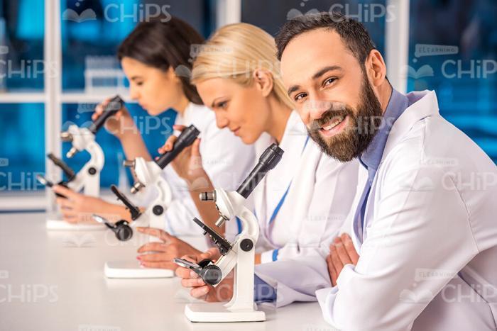 Bearded Male Researcher With Colleagues Stock Photo
