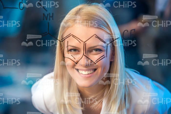 Blonde Female Scientist Having Fun While Looking Through Chemical Formula Stock Photo