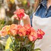 Smiling Woman Taking Flower From Bouquet Stock Photo