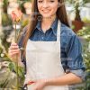 Smiling Woman In Gardener's Apron Holds Flower Stock Photo