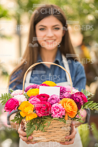 Woman Gardener Holding Basket Of Flowers Stock Photo