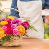 Gardener With Basket Of Flowers Holding Card Sample Stock Photo