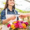Smiling Gardener Taking Buyer's Credit Card Stock Photo