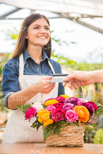 Smiling Gardener Taking Buyer's Credit Card Stock Photo