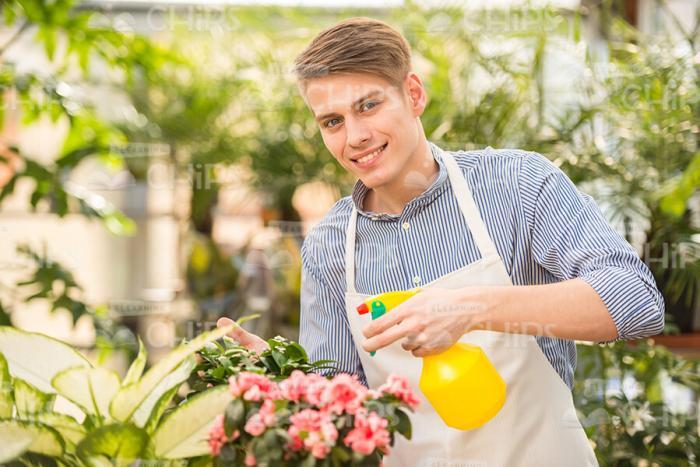 Handsome Man Smiles And Sprays Flowers Stock Photo