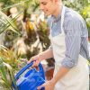 Gardener Using Watering Can Stock Photo