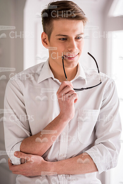 Pensive Young Man Crossed Arms Stock Photo