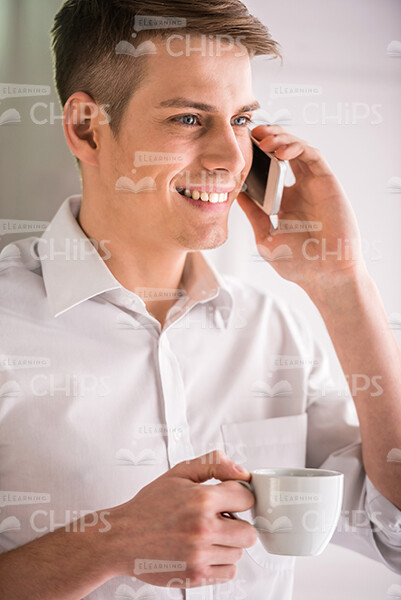 Attractive Young Business Man Talks On Mobile Phone Stock Photo