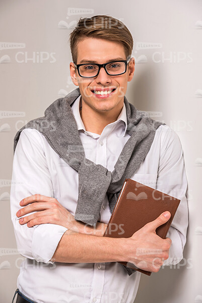 Nice Businessman Crosses Arms And Holds Notebook Stock Photo
