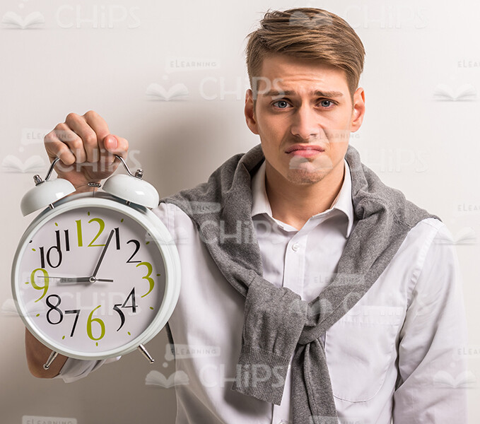 Sad Young Man Holding Clocks Stock Photo