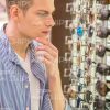 Thoughtful Young Man Choosing New Glasses Stock Photo