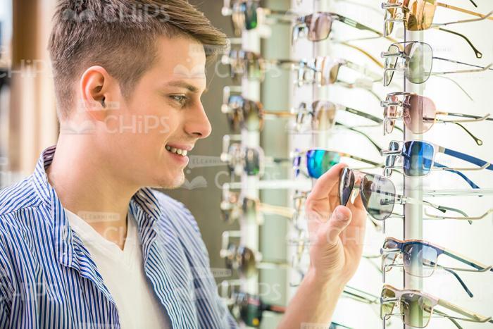 Teenager Choosing Glasses In Shop Stock Photo
