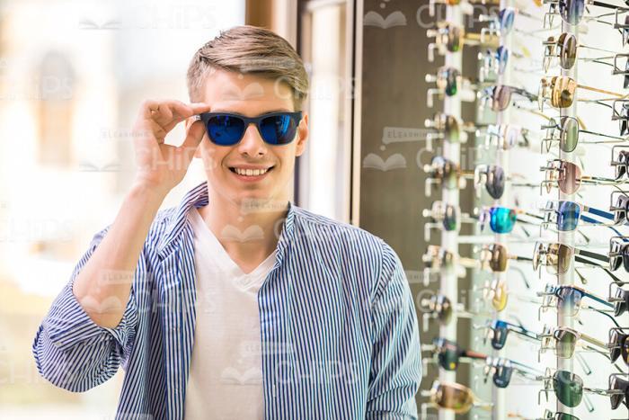 Young Man Wearing New Glasses At Shop Stock Photo