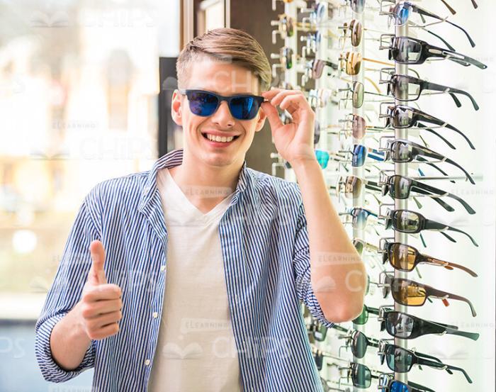Nice Man At Sunglasses Shop Showing Thumb Up Stock Photo