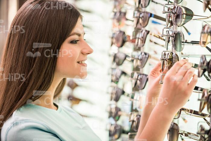 Smiling Woman Choosing Glasses Profile View Stock Photo