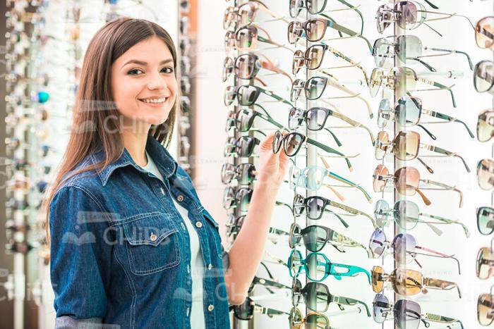 Happy Girl Holding Glasses At Shop Stock Photo