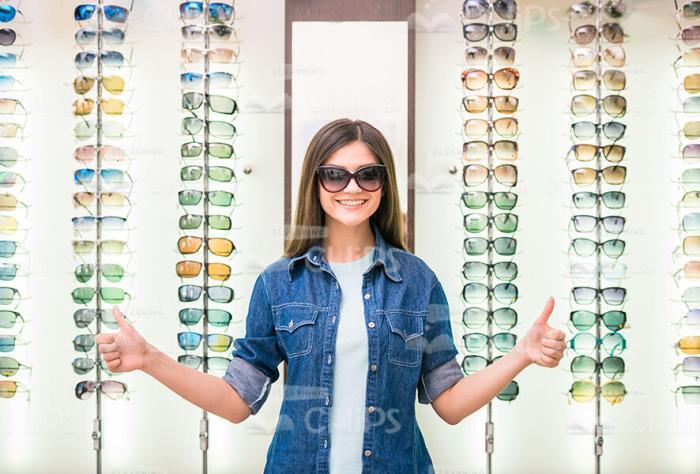 Woman Shows Her Thumbs Up At Glasses Store Stock Photo