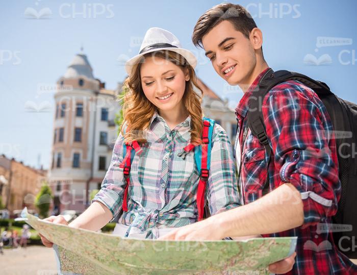 Young Tourists Looking At Map Stock Photo
