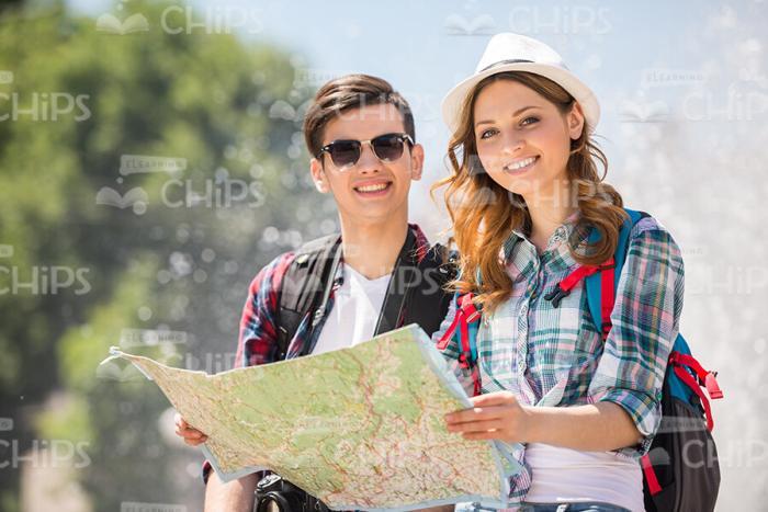 Smiling Tourists With Map Walking Through The City Stock Photo