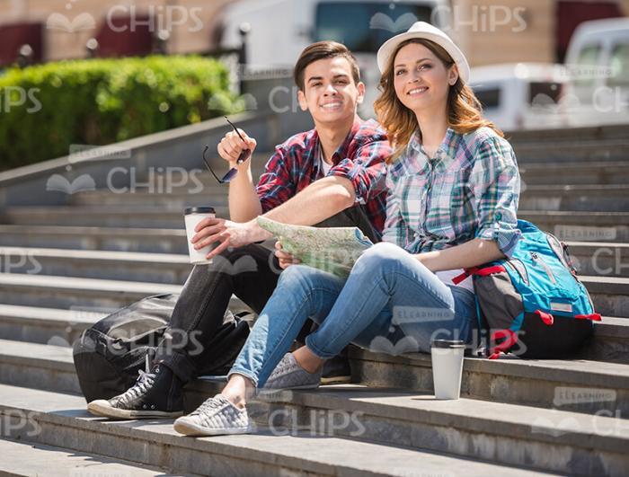 Couple Of Tourists Sitting Of Stairs Stock Photo