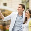 Young Man Pointing Forward While Something To Girlfriend Stock Photo