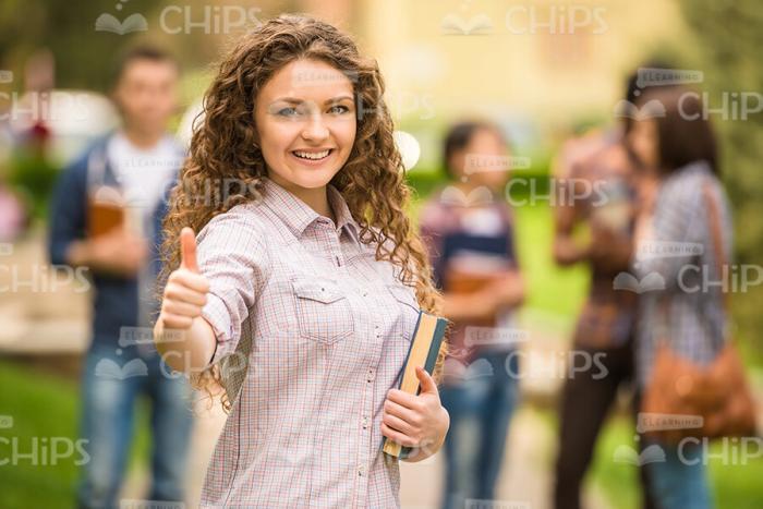 Stock Photo Of Curly Student Showing Thumb Up Gesture