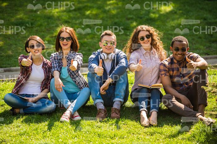 Young People Making Thumbs Up Gestures Together Stock Photo