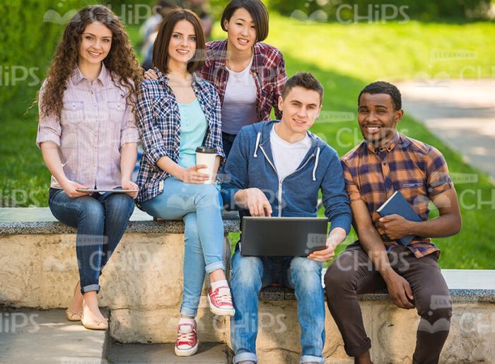 Happy Guys Sitting Outdoors Stock Photo