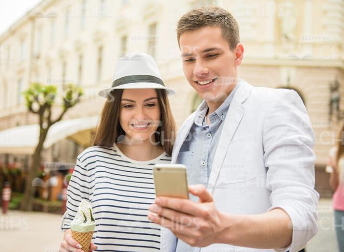 Young Couple Looking At Smartphone's Screen Stock Photo