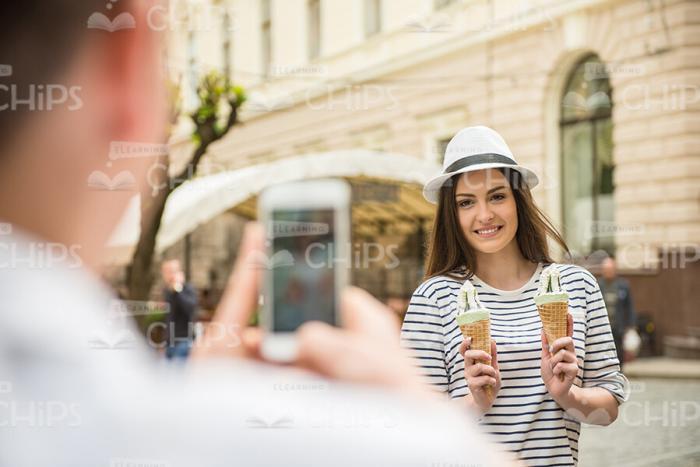 Smiling Young Woman Holding Two Ice Creams And Posing For Camera Stock Photo