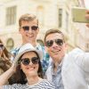 Four Friends Wearing Sunglasses And Taking Photo Together Stock Photo
