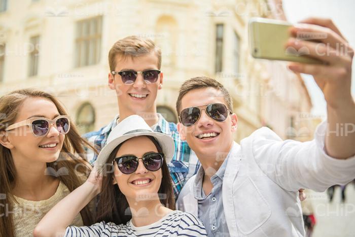 Four Friends Wearing Sunglasses And Taking Photo Together Stock Photo