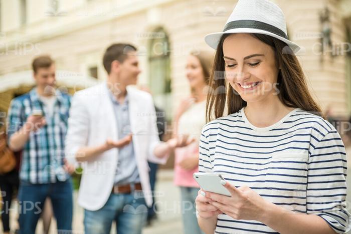 Girl In Stripped T-shirt Texting To Somebody Stock Photo