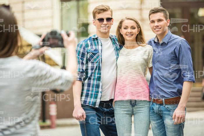 Young Girl Photographing Her Friends Stock Photo