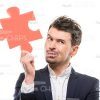 Thoughtful Man Holding Puzzle Piece Stock Photo