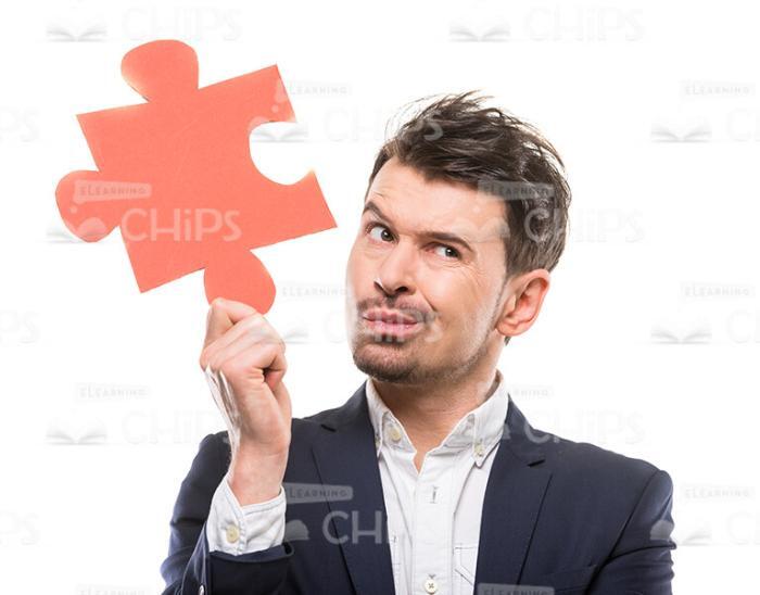 Thoughtful Man Holding Puzzle Piece Stock Photo