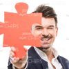 Confident Young Business Man Looks Through Puzzle Piece Stock Photo
