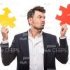 Nice Businessman Choosing Between Two Puzzle Pieces Stock Photo